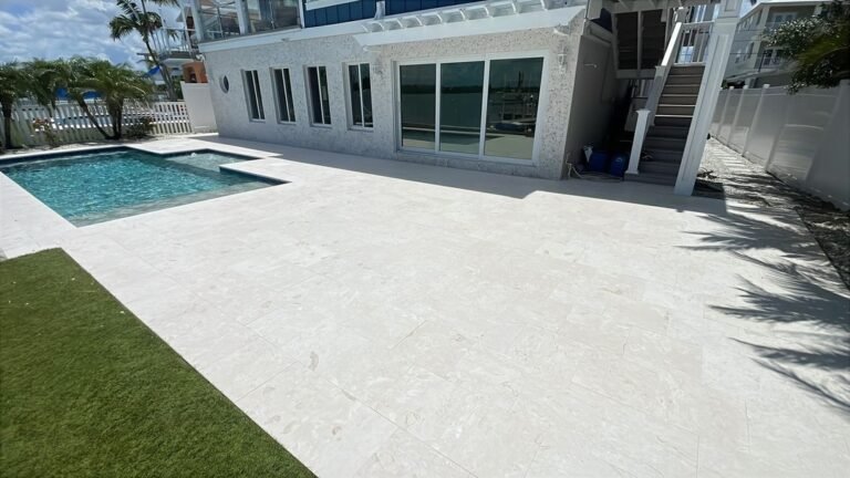 Completed waterfront travertine pool deck around a residential pool in Tampa Bay