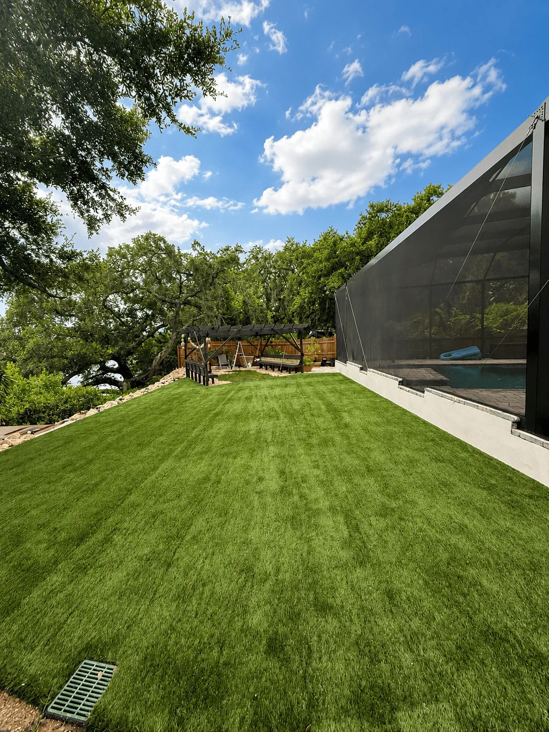 Completed artificial turf lawn with a uniform green finish in a Tampa backyard