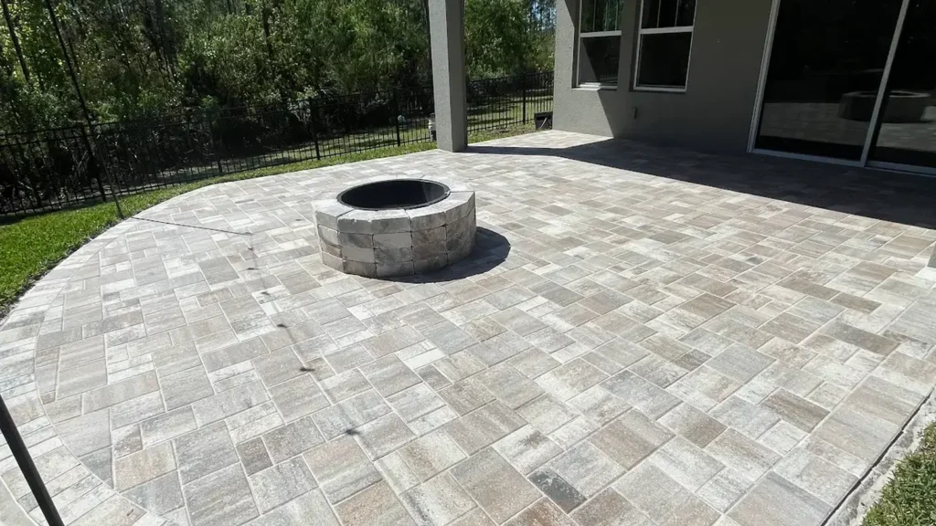 stone fire pit on a large paver patio in a Tampa Bay backyard