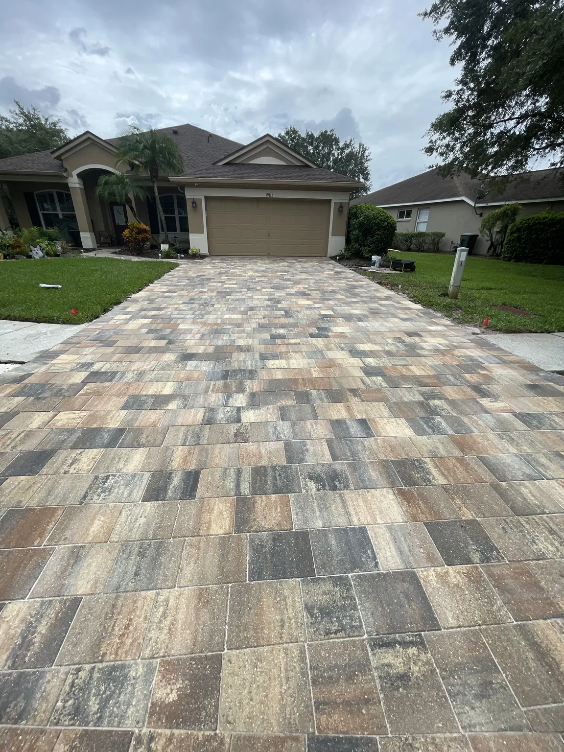 Completed gray tan and charcoal paver driveway in front of a Tampa Bay home