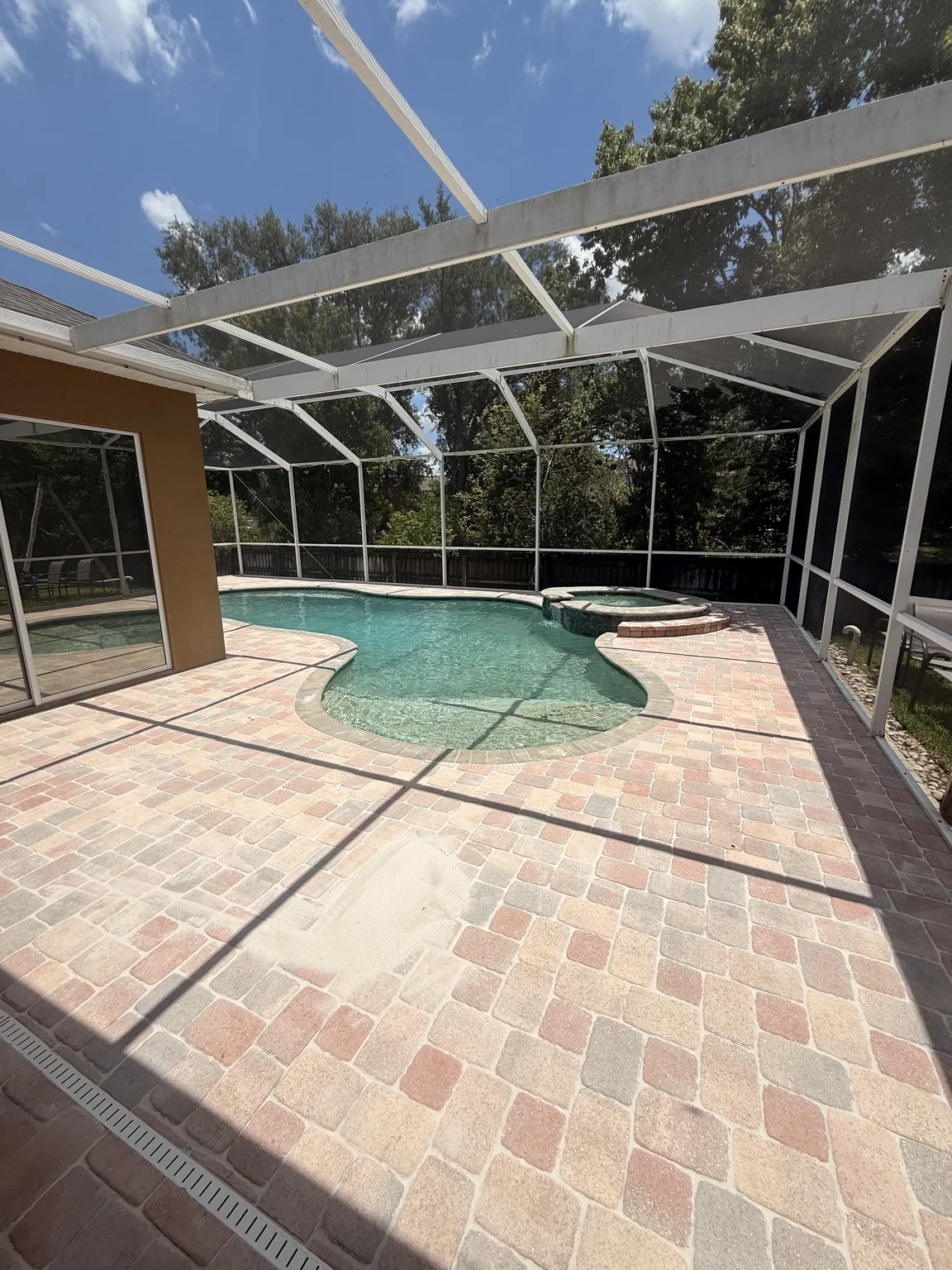Screened pool deck before professional paver sealing in Tampa Bay