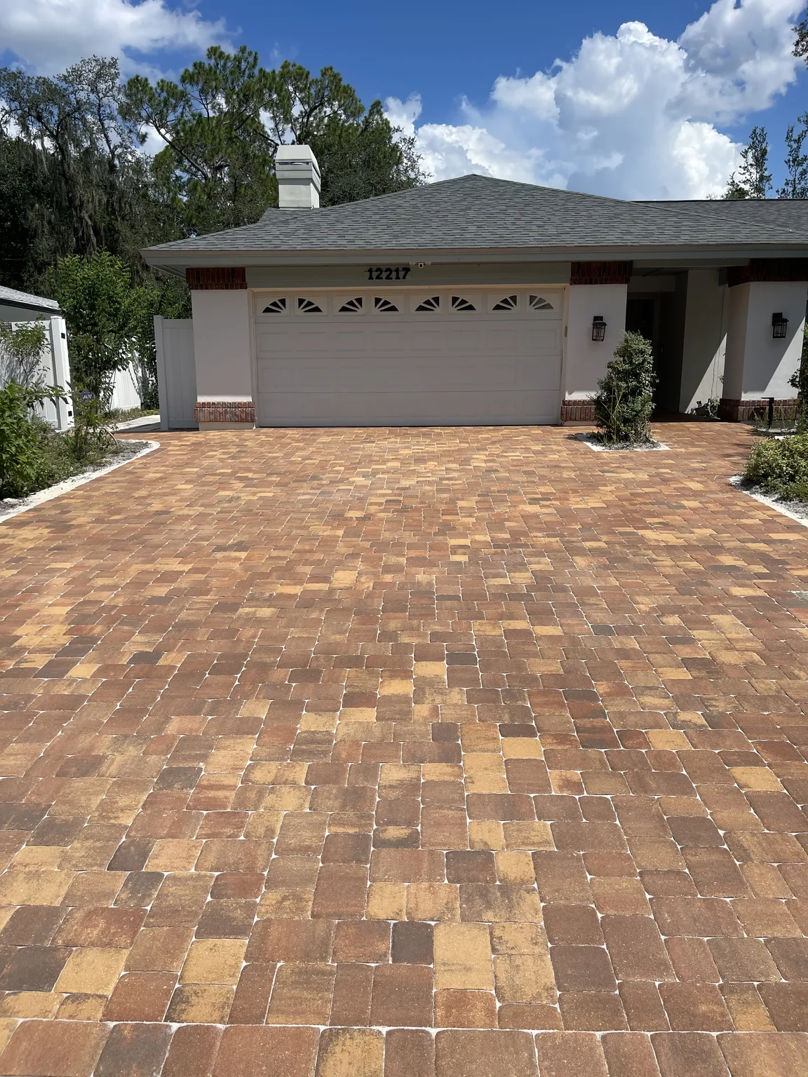 Completed warm brown paver driveway leading to a Tampa Bay home